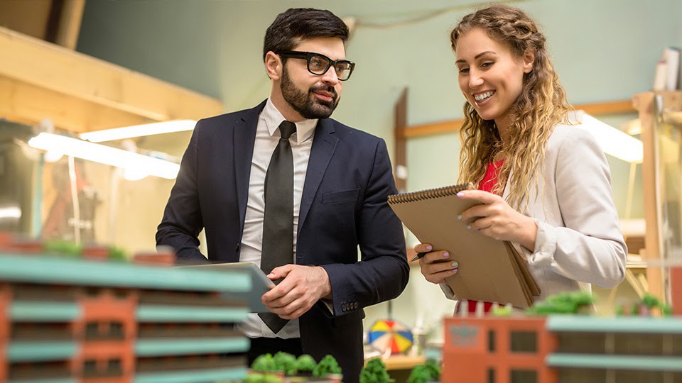 Male and female social workers looking at a clipboard noting city planning topics